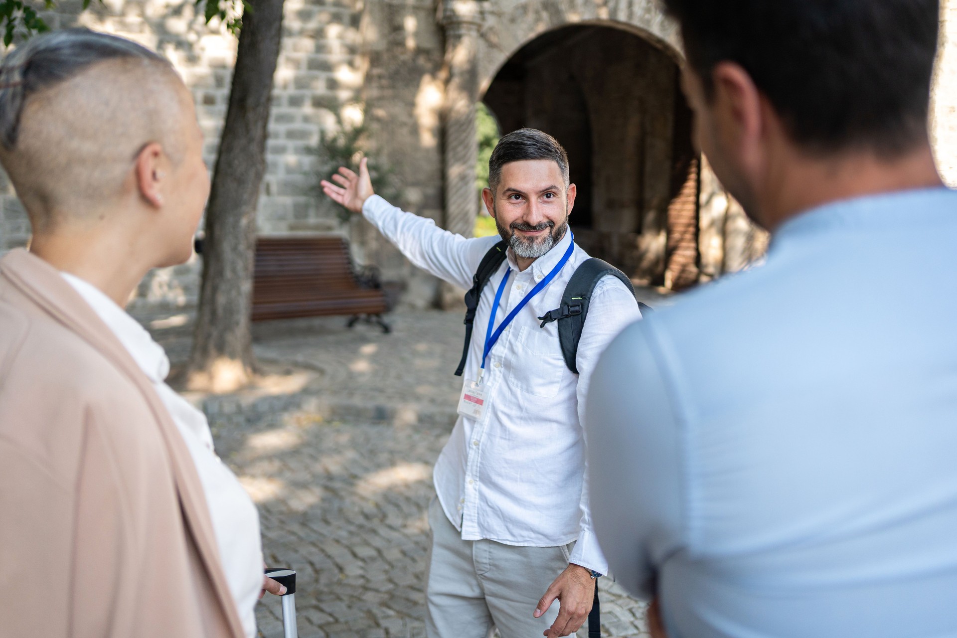 Tour guide explaining historical site details to a group of tourists outdoors